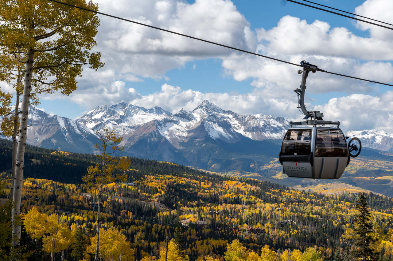 Telluride gondola through golden autumn aspens with Wilson Peak beyond